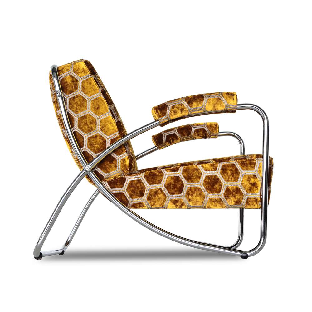 Dyker 20 chroombuisfauteuil bekleed met Manipur oker van Designers Guild, met grafisch zeshoekig dessin en gestoffeerde armleggers. DSCO.NL